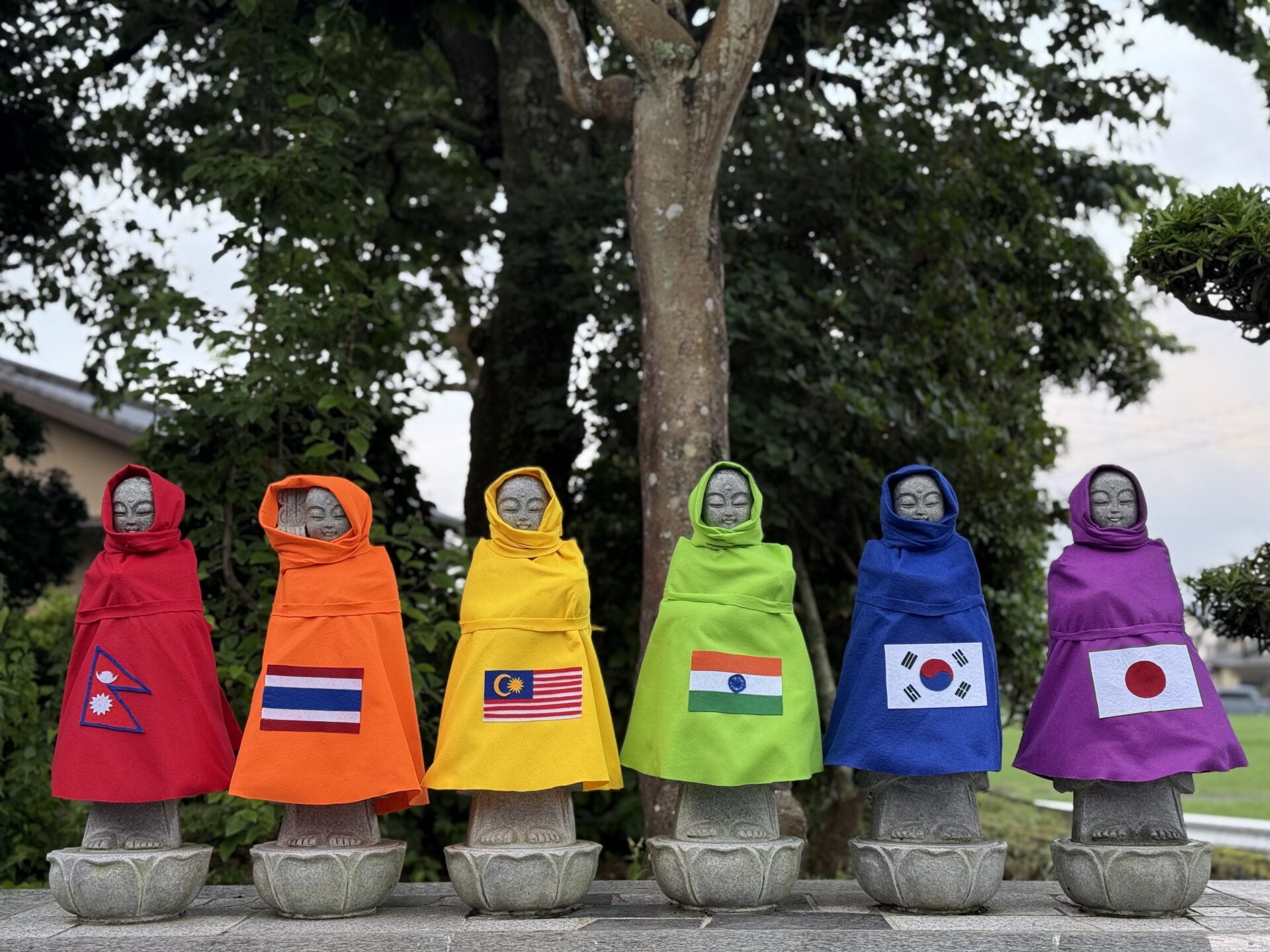 Six Jizo statues dressed in rainbow colors at Komyoji Temple
